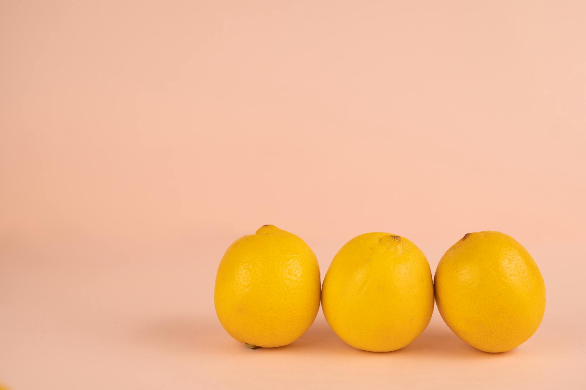 A blue clitoral vibrator surrounded by fresh flowers and citrus slices on a bright yellow background